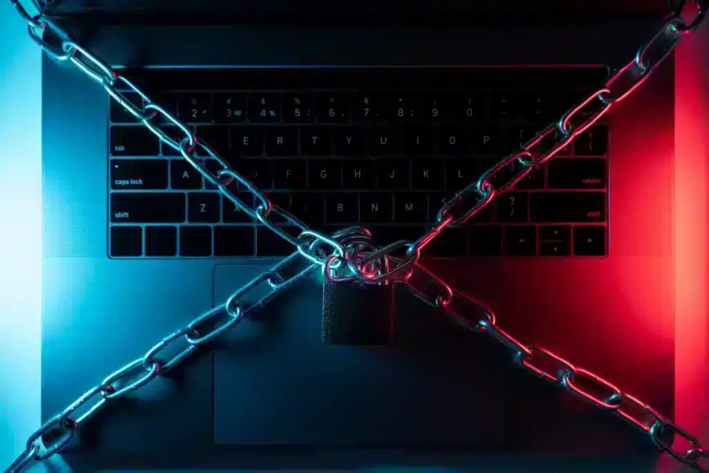 Notebook preso por correntes representando o ataque de ransomware